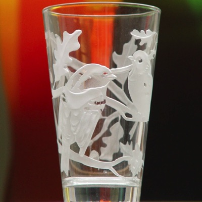 Ein Trinkglas mit Vögeln darauf. Wir in einem Glasworkshop gemacht.